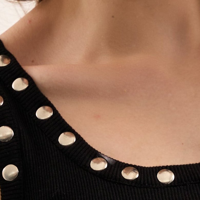 Rivets, framing the neckline, on the Midnight tank